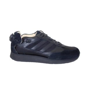 A black shoe with a cream-coloured lining and a small device on the back to lace it up.