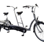 The Twinny Tandem is a two-person bike with two sets of handlebars, two sets of pedal cranks, and an extended frame. It has three wheels for stability.
