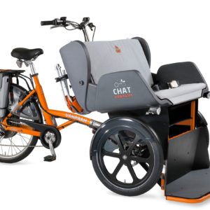 A Van Raam Chat Rickshaw, which has a bike at the back to pedal, and room for two people to sit on a chair-like space in front.