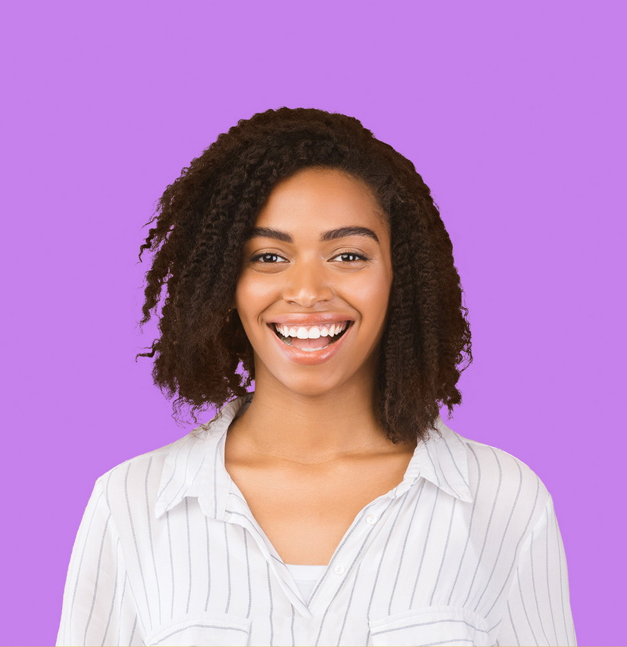 A Black woman smiling at the camera in a striped shirt. She is in front of a purple background.