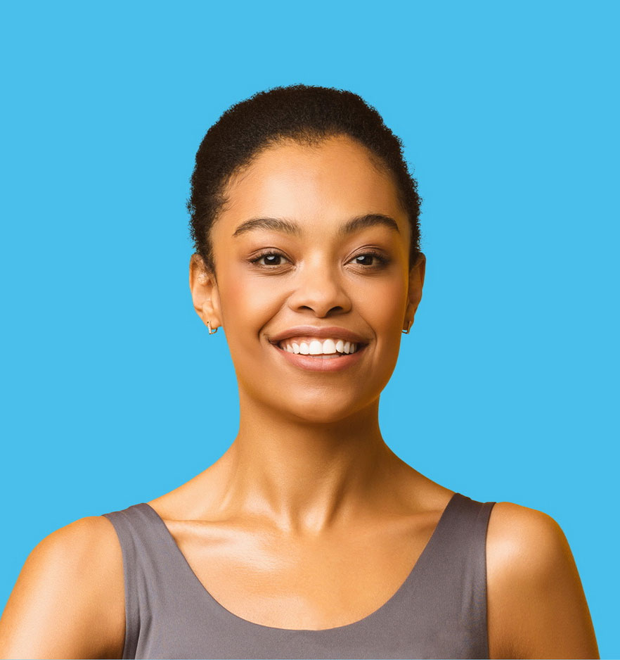 A Black woman in a tank top, with her hair in a ponytail. She is smiling at the camera. The background is blue.