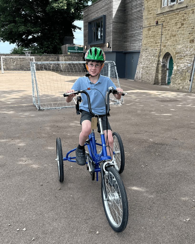 Little boy smiling while riding a Tomcat 'Fizz' in his school playground